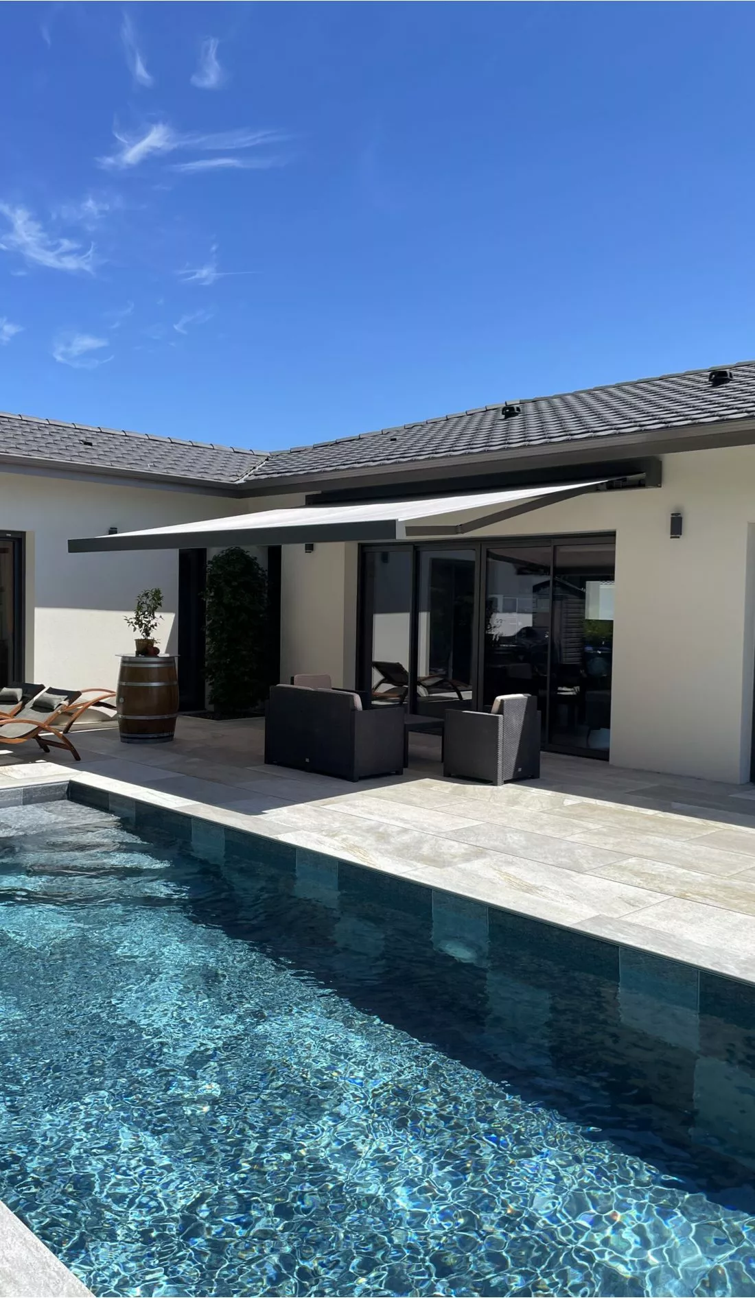 Store banne au-dessus d'une terrasse avec piscine